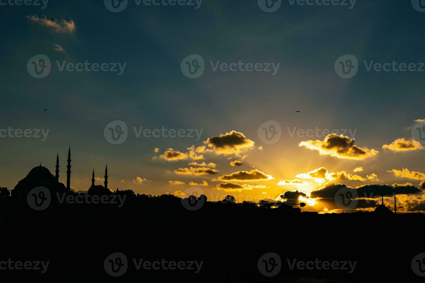 Silhouette of Istanbul at sunset and crepuscular rays. Islamic concept photo