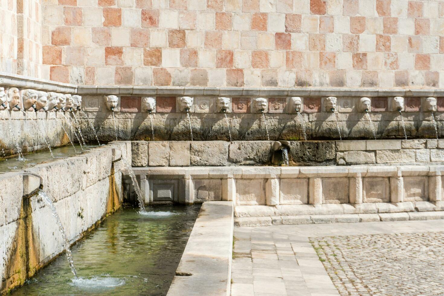 L'Aquila, Italy-august 11, 2021-Particular of the Fountain of 99 Spouts during a sunny day photo