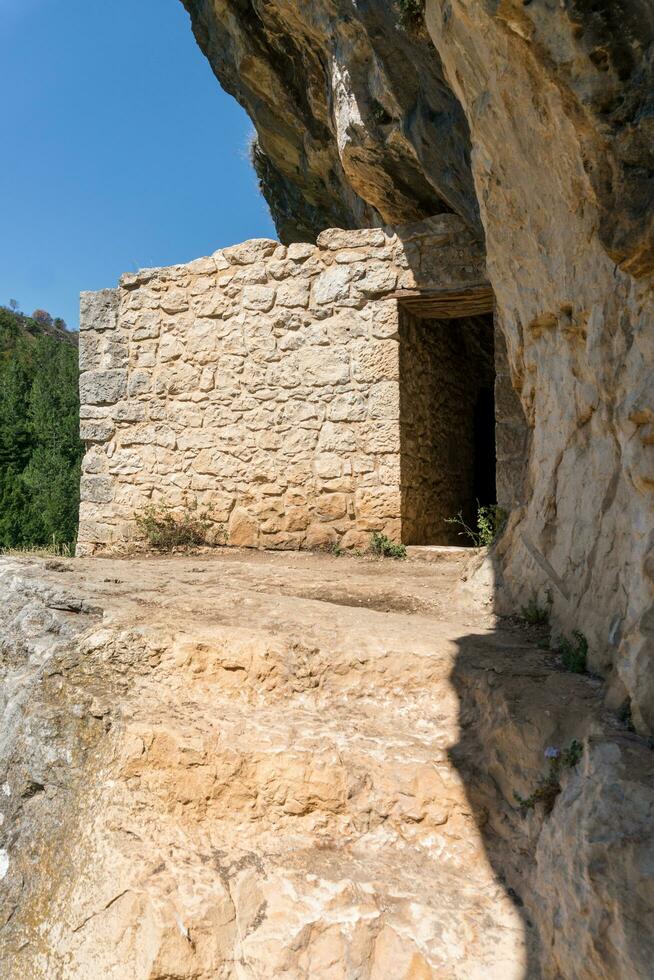 L'Aquila, Italy-august 12, 2021-Hermitage of San Bartolomeo an ancient church dug into a cliff with a well-preserved fresco, altar and hermit's cells. photo