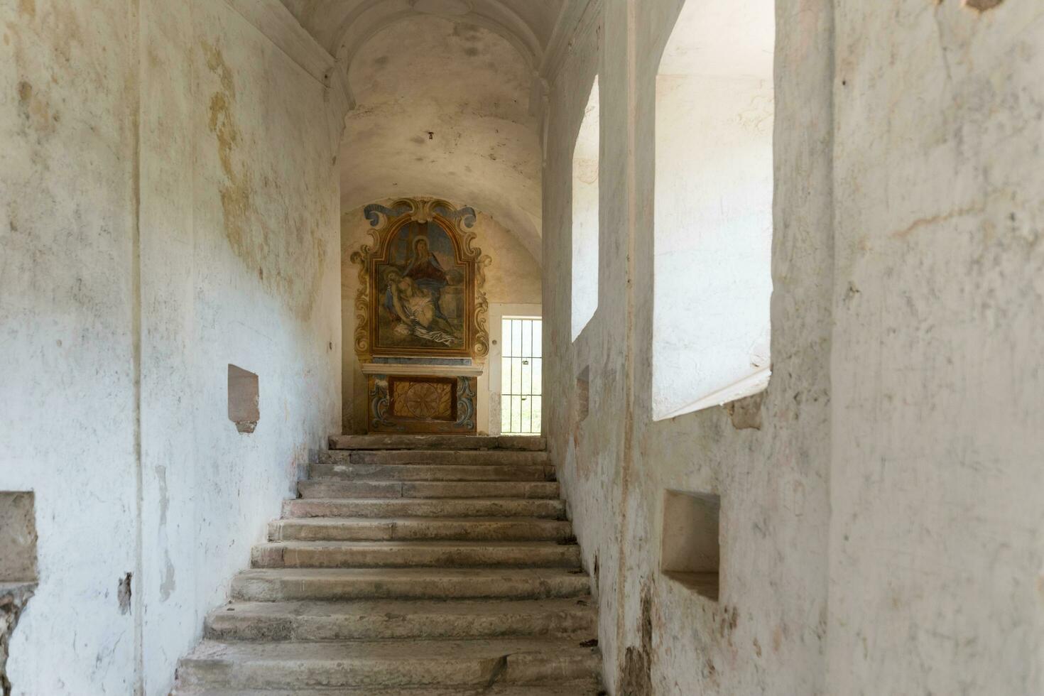 L'Aquila, Italy-august 12, 2021-ruins of the Hermitage of the Holy Spirit an ancient church dug into a cliff with a well-preserved fresco, altar and hermit's cells. photo