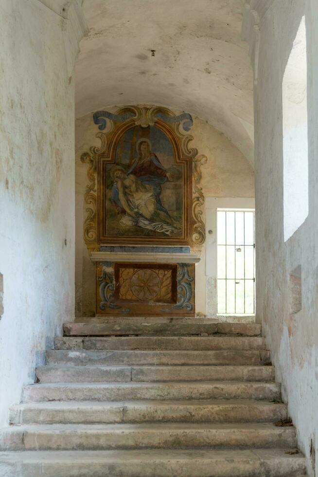 L'Aquila, Italy-august 12, 2021-ruins of the Hermitage of the Holy Spirit an ancient church dug into a cliff with a well-preserved fresco, altar and hermit's cells. photo