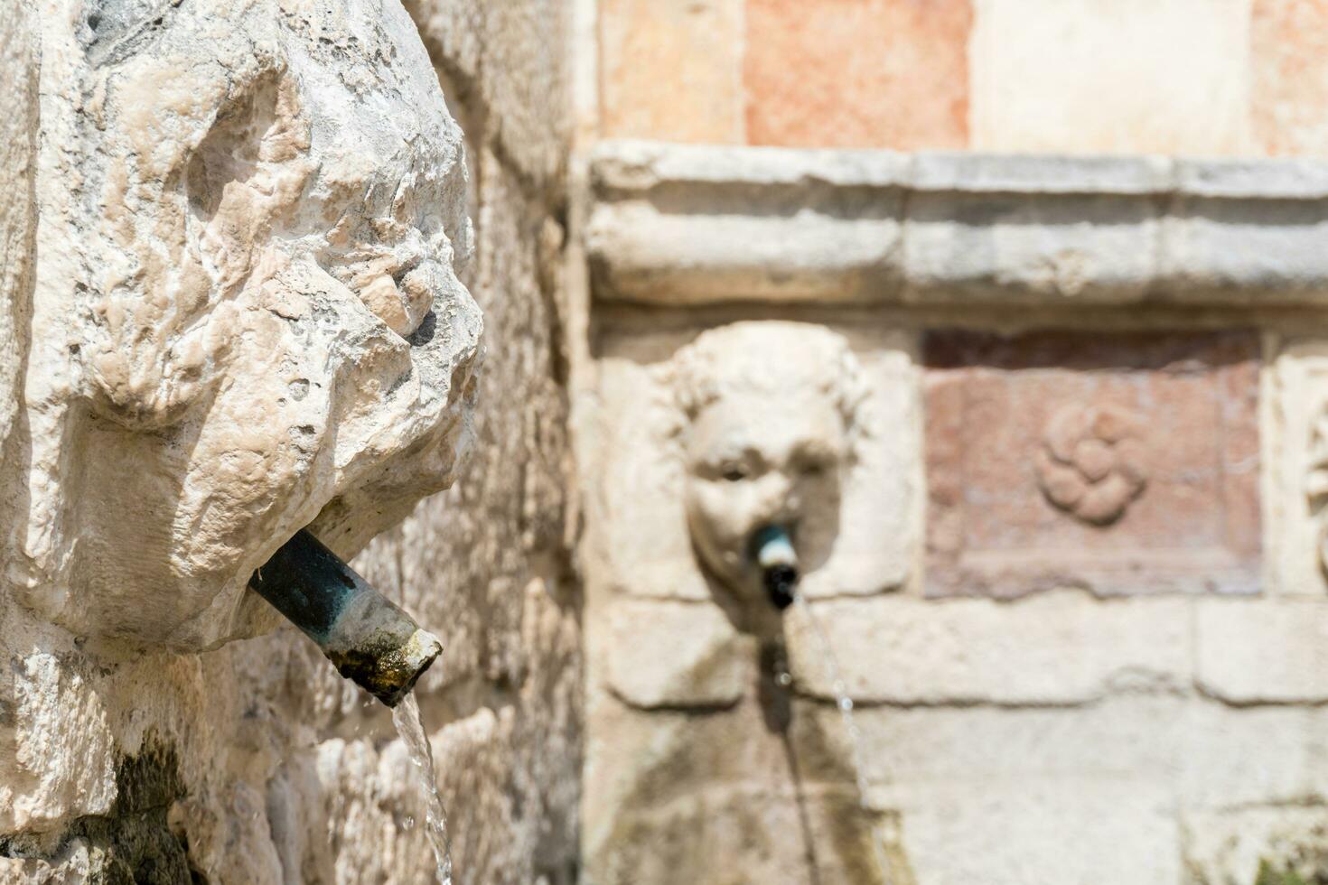 L'Aquila, Italy-august 11, 2021-Particular of the Fountain of 99 Spouts during a sunny day photo