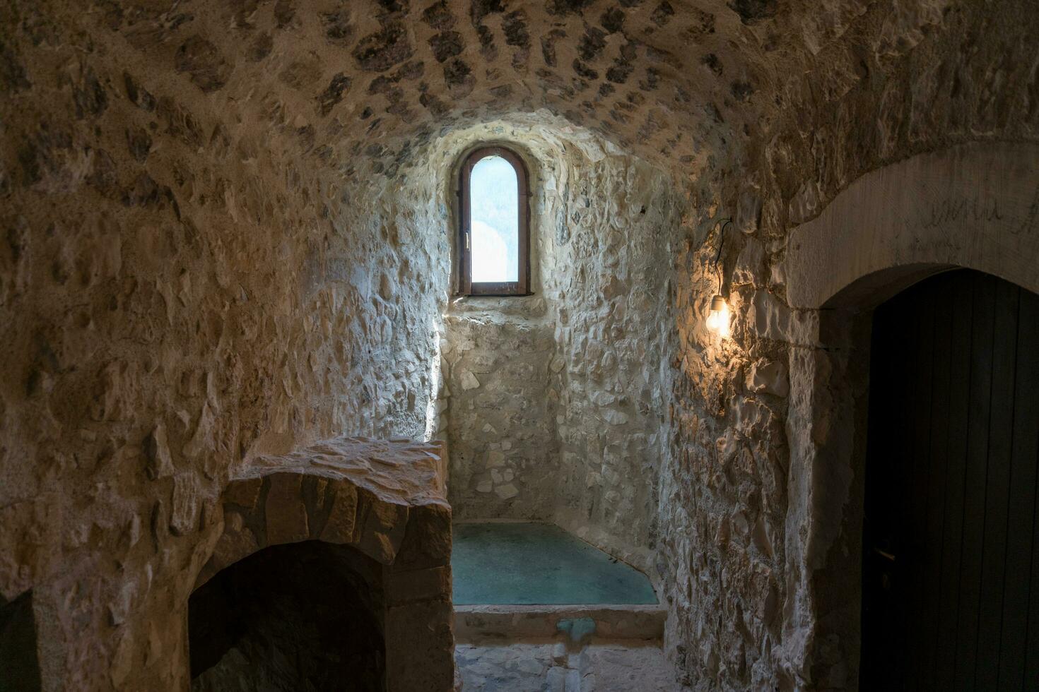 L'Aquila, Italy-august 12, 2021-ruins of the Hermitage of the Holy Spirit an ancient church dug into a cliff with a well-preserved fresco, altar and hermit's cells. photo