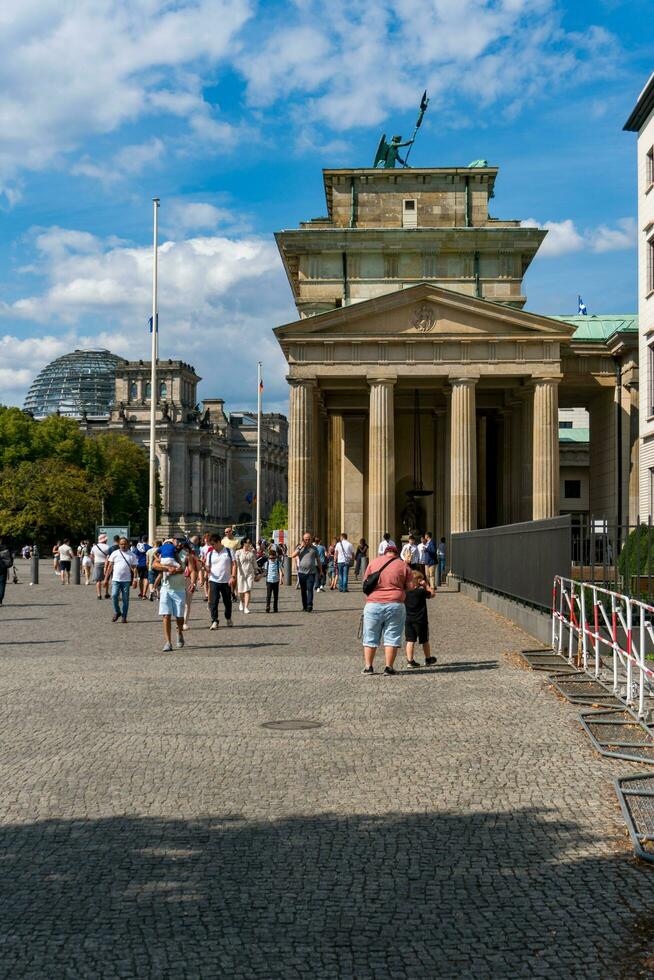 Berlin, Germany-august 9, 2022-people strolling near the Brandeburg gate during a sunset photo