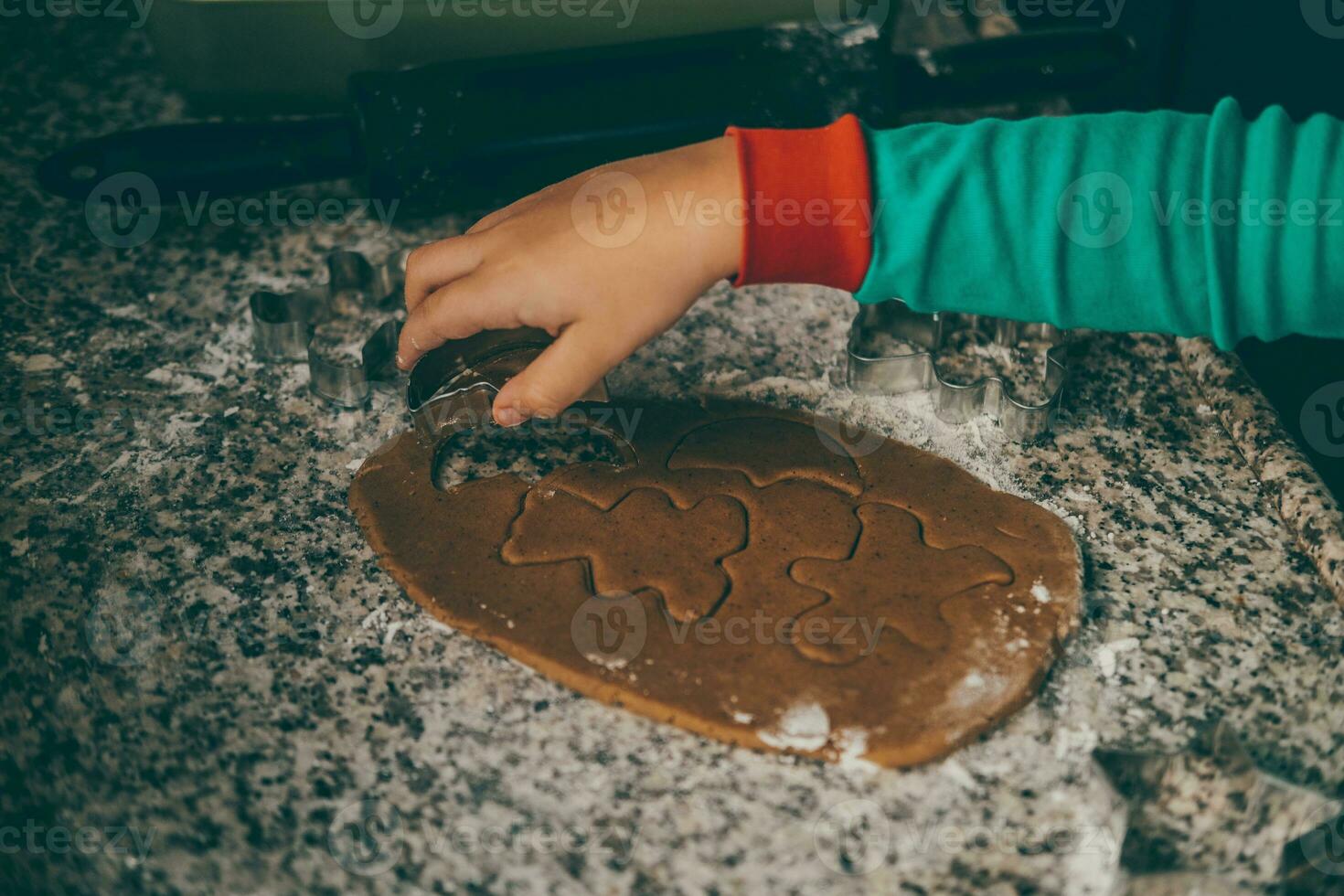 Mom and her adorable son create magical moments in the kitchen, preparing Christmas gingerbread photo
