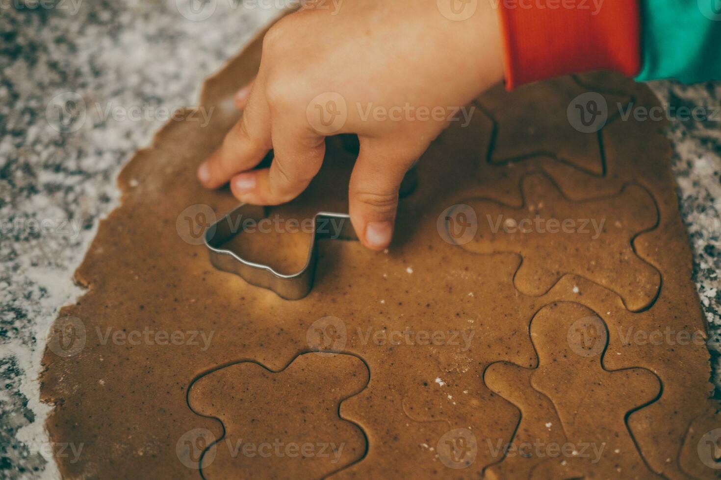 un mamá y su hijo contratar en el encantador tarea de preparando Navidad pan de jengibre foto