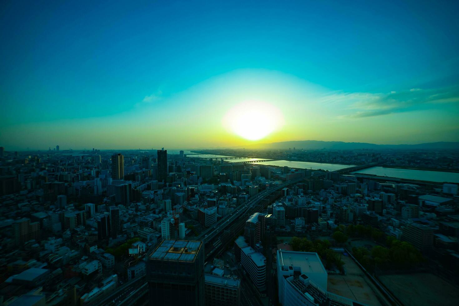 un puesta de sol panorámico paisaje urbano cerca Yodo río en Osaka amplio Disparo foto