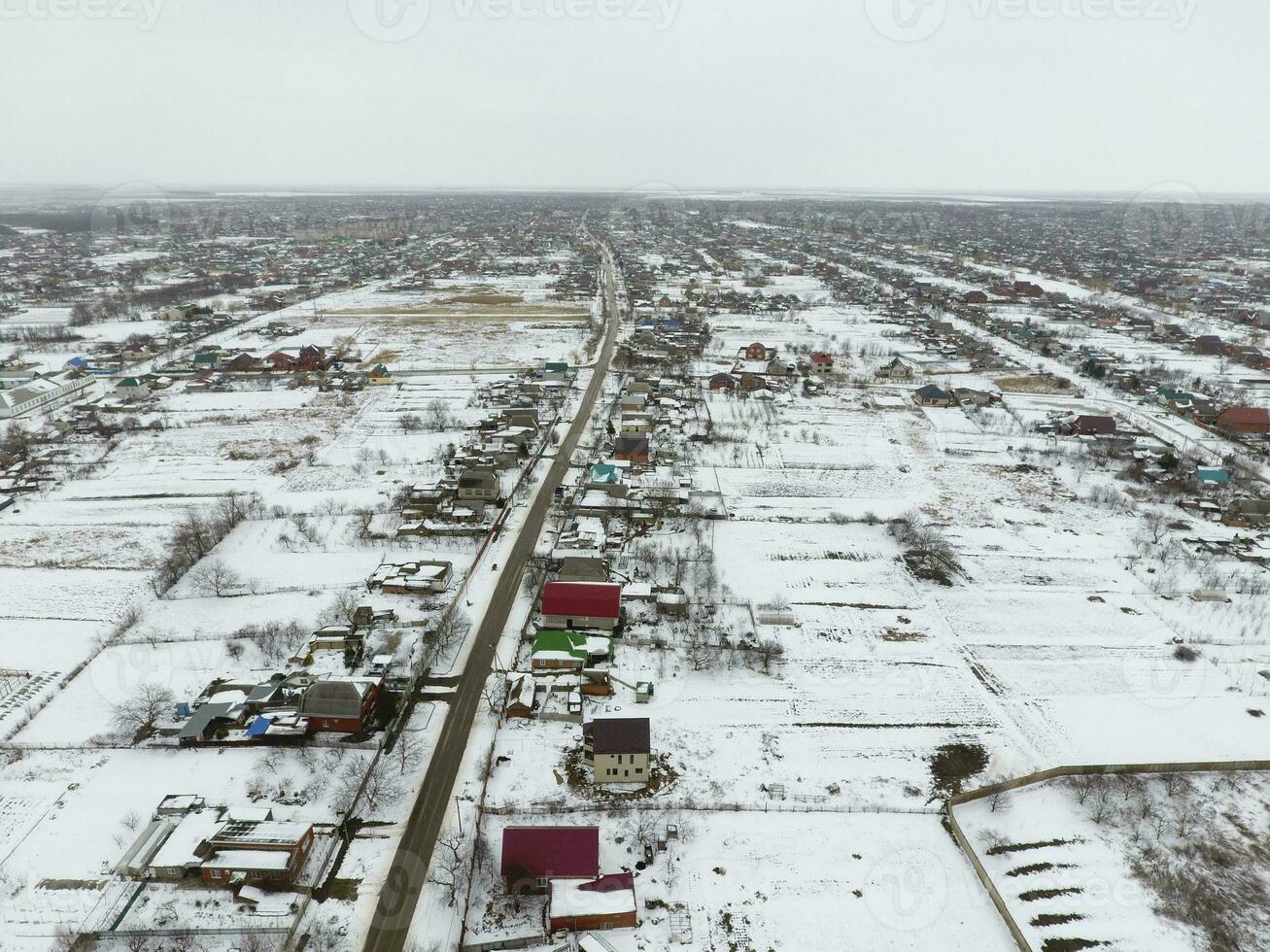 invierno ver desde el aves ojo ver de el aldea. el calles son cubierto con nieve foto