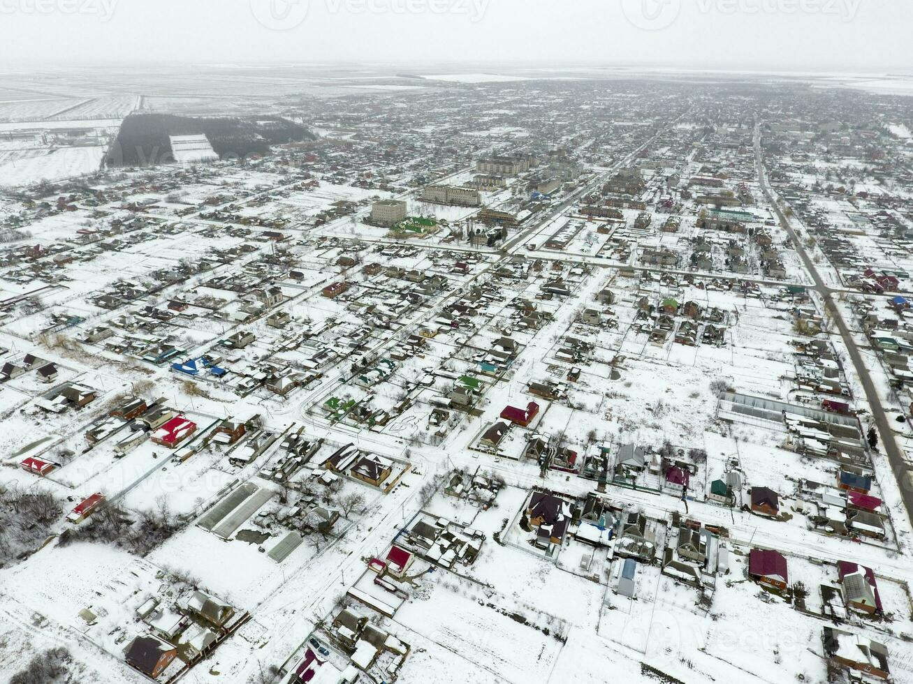 invierno ver desde el aves ojo ver de el aldea. el calles son cubierto con nieve foto