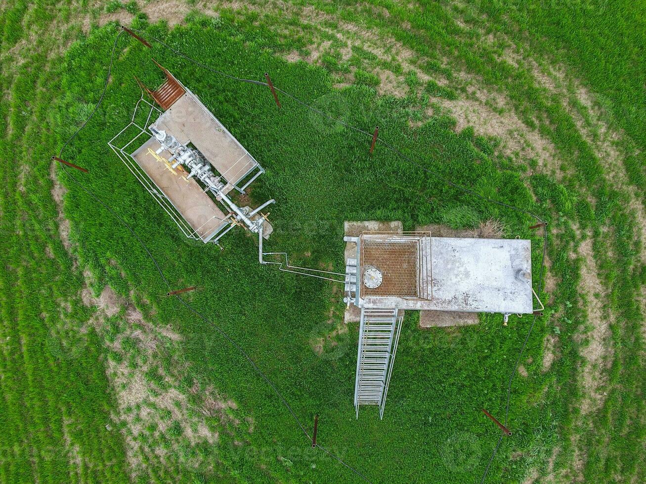 Equipment of an oil well. A tank with methanol near the oil well. Shutoff valves and service equipment photo