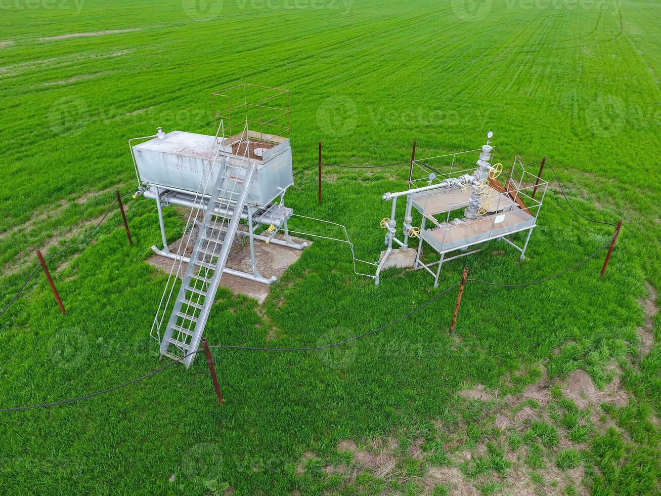 Equipment of an oil well. A tank with methanol near the oil well. Shutoff valves and service equipment photo