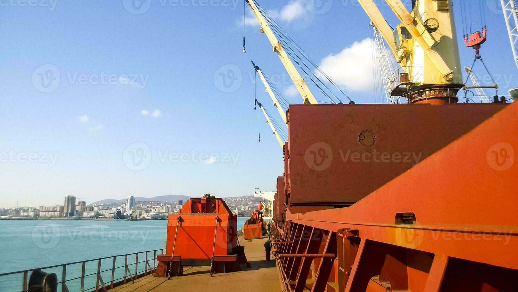 View of the sea and city beach from the port quay. Industrial port with tower cranes and cargo infrastructure photo