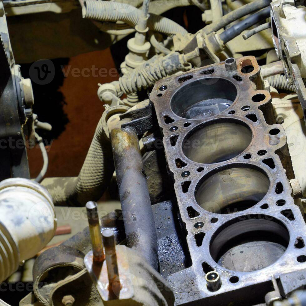 The cylinder block of the four-cylinder engine. Disassembled motor vehicle for repair. Parts in engine oil. Car engine repair in the service photo