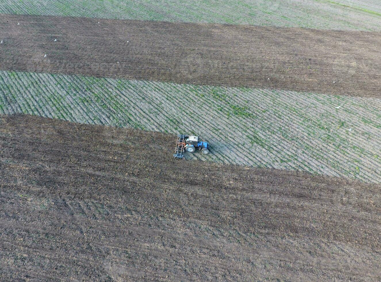 Top view of the tractor that plows the field. disking the soil. Soil cultivation after harvest photo