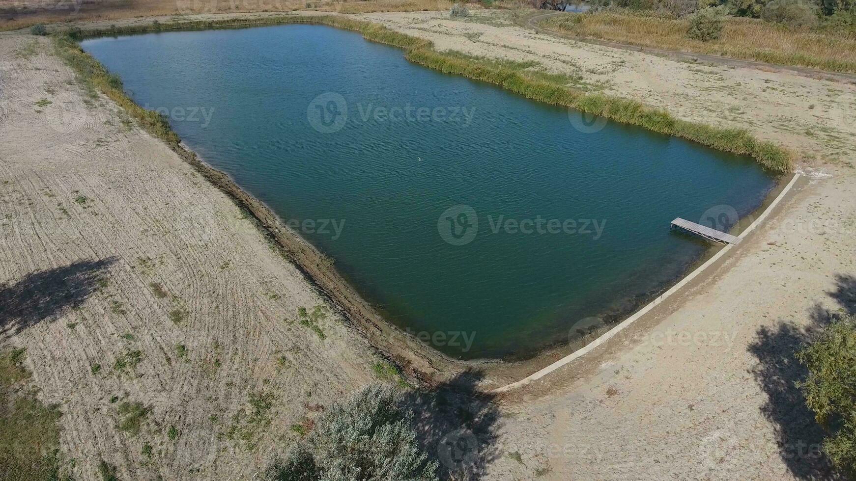 An artificial lake for fishing. A bridge for fishermen on the lake. Lake fishing. photo