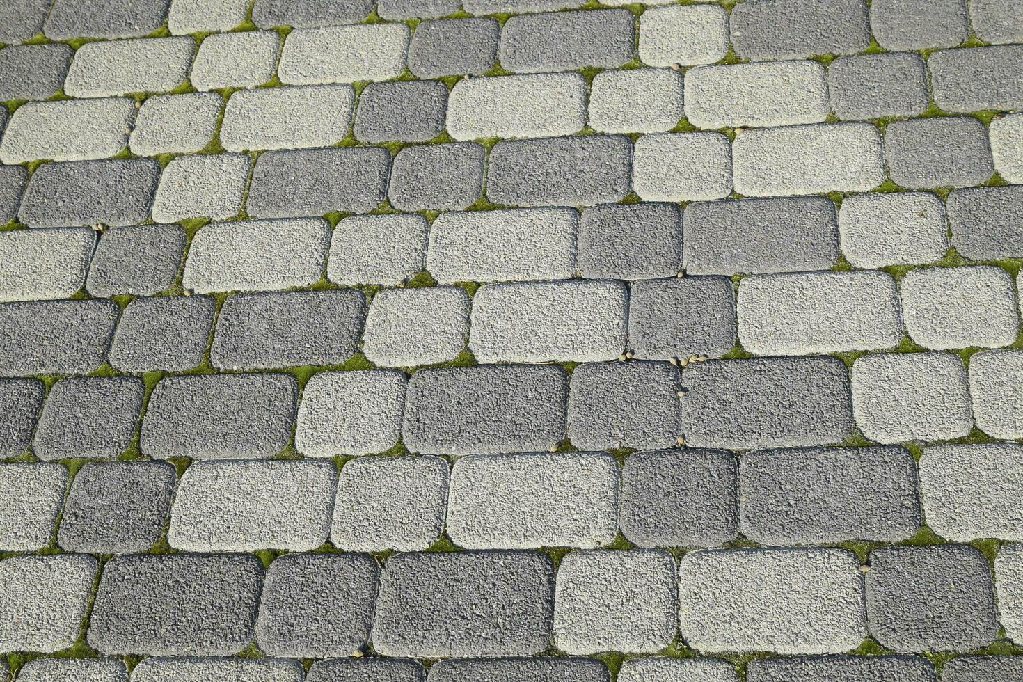 Industrial building background of paving slabs with overgrown wi photo