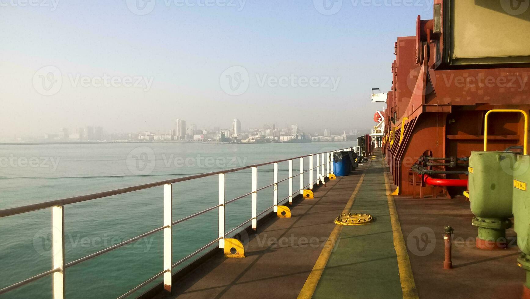View of the sea and city beach from the port quay. Industrial port with tower cranes and cargo infrastructure photo