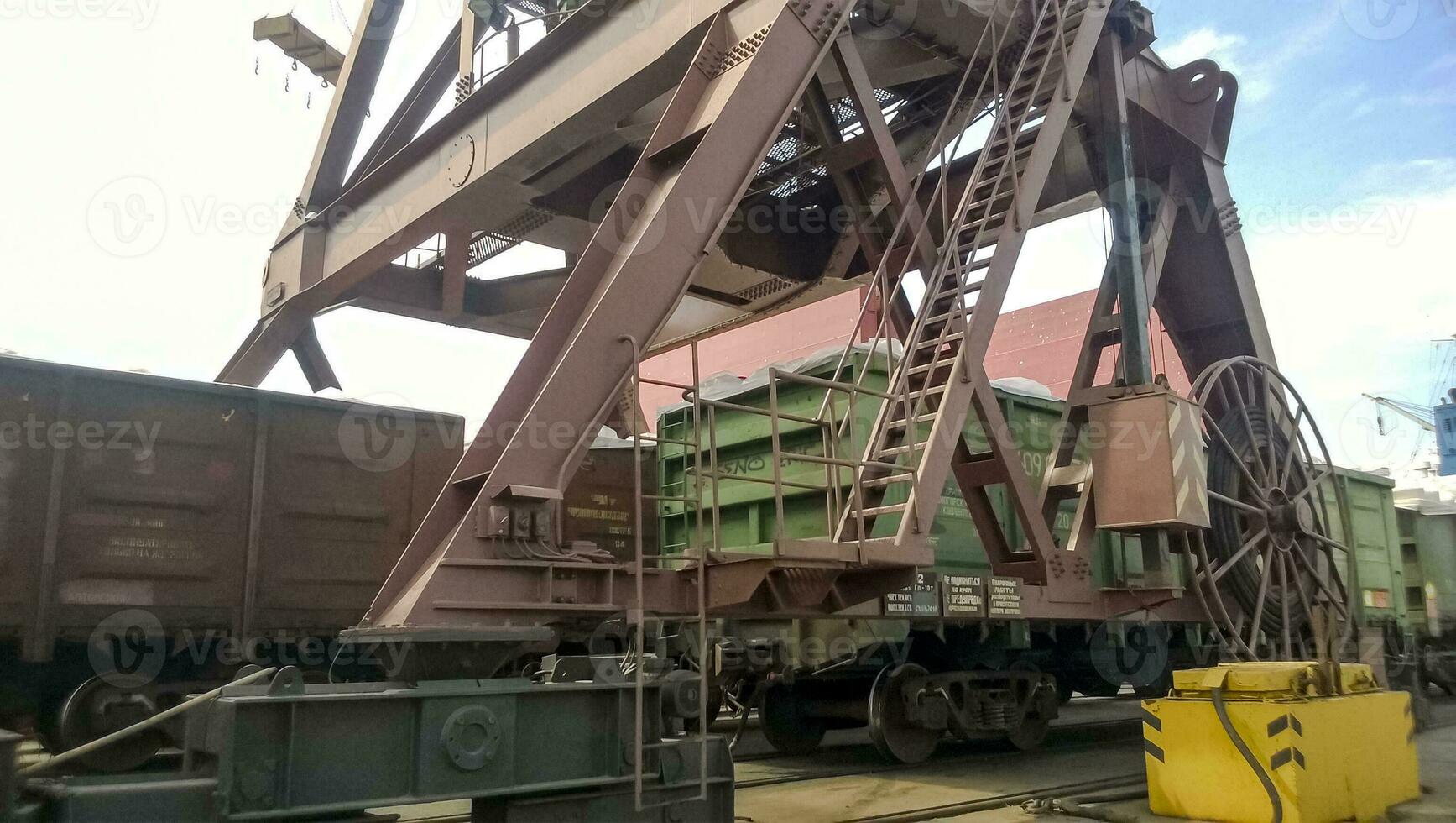 Loaded freight cars in the port. Passage of cars under the tower crane photo