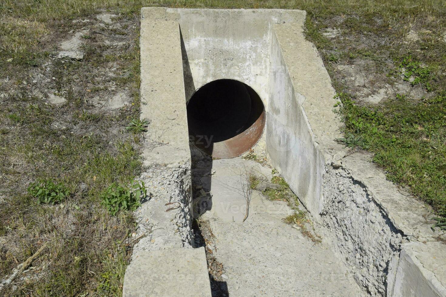 Tunnel for draining rainwater under the road. View through the pipe photo