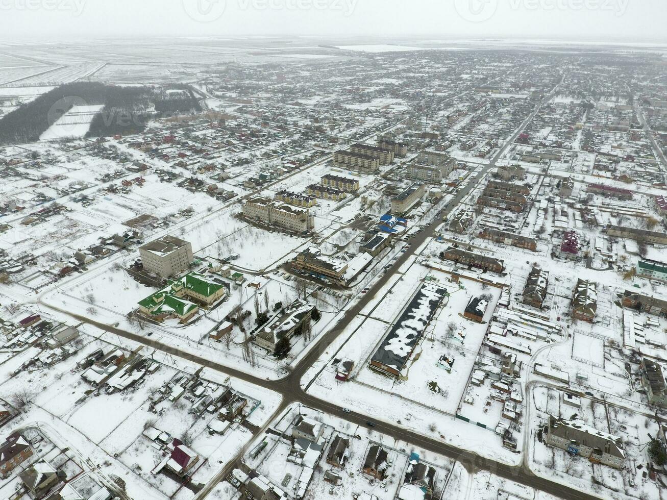 invierno ver desde el aves ojo ver de el aldea. el calles son cubierto con nieve foto