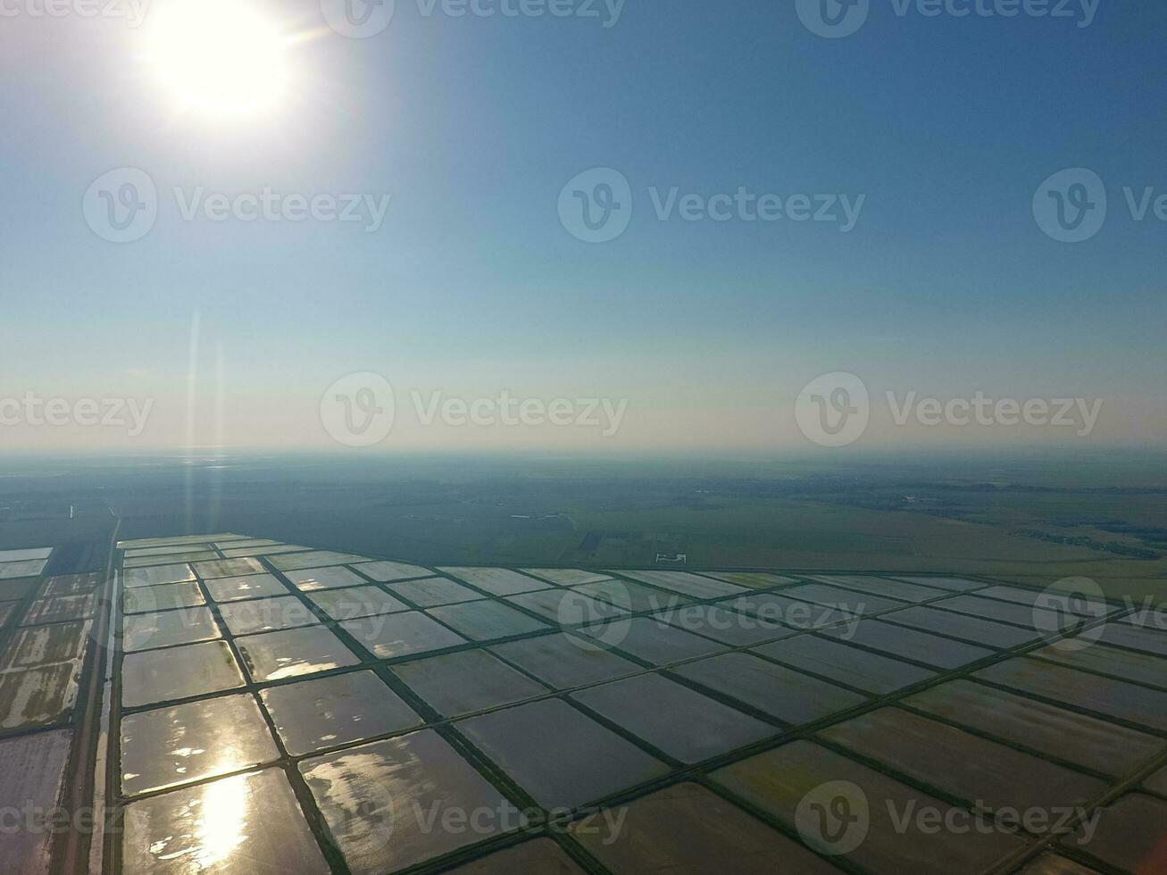 el arroz campos son inundado con agua. paisaje en frente de el Dom. inundado arroz arrozales agronómico métodos de creciente arroz en el campos. foto