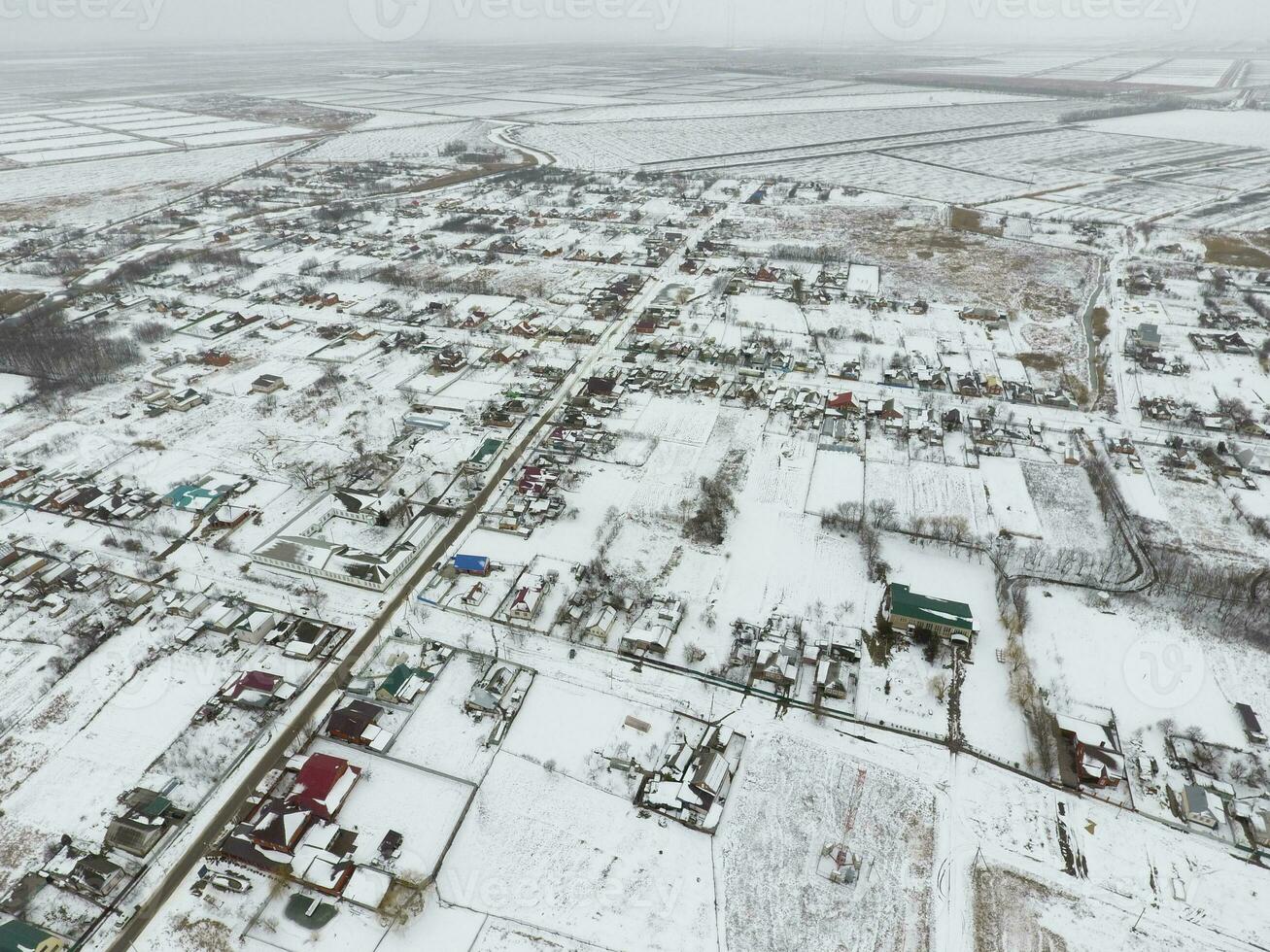 invierno ver desde el aves ojo ver de el aldea. el calles son cubierto con nieve foto