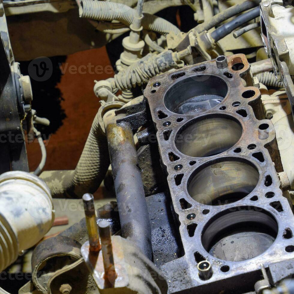 The cylinder block of the four-cylinder engine. Disassembled motor vehicle for repair. Parts in engine oil. Car engine repair in the service photo