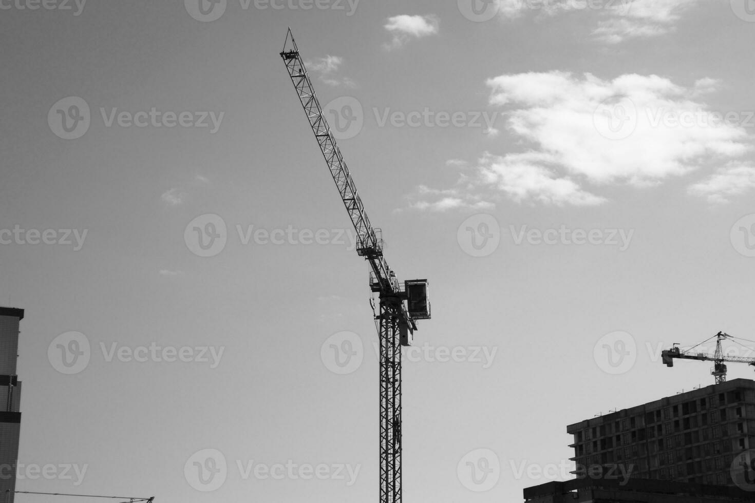 Tower building crane against the blue sky and sun. Construction of new buildings with a crane. Tower crane photo