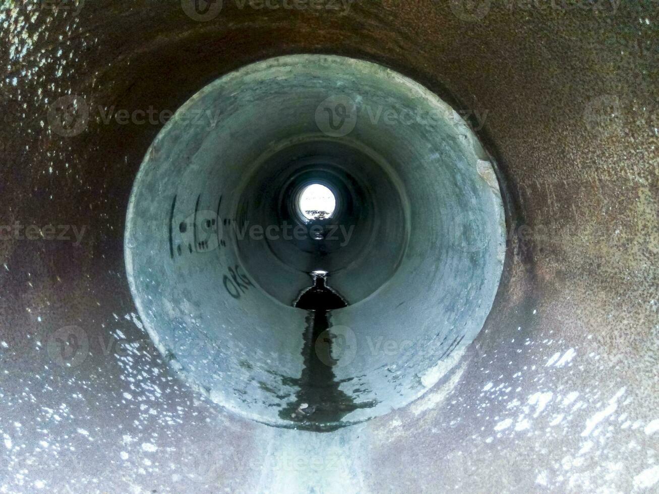 Tunnel for draining rainwater under the road. View through the pipe photo