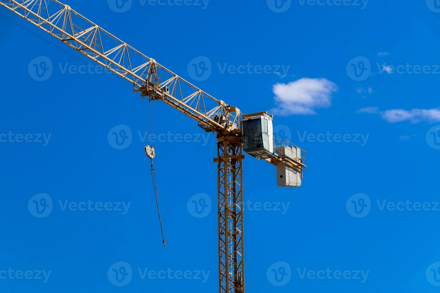 Tower building crane against the blue sky and sun. Construction of new buildings with a crane. Tower crane photo