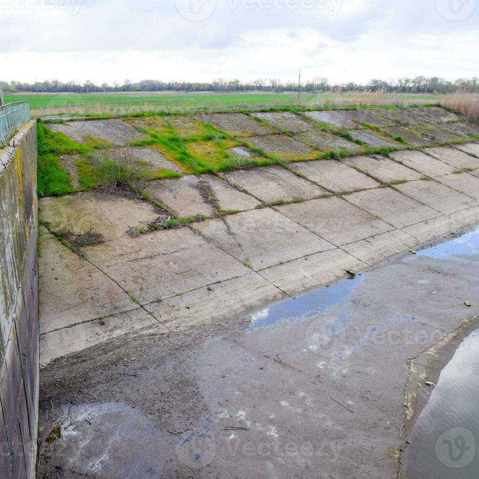 Paved concrete banks of the irrigation canal at the outlet of th photo