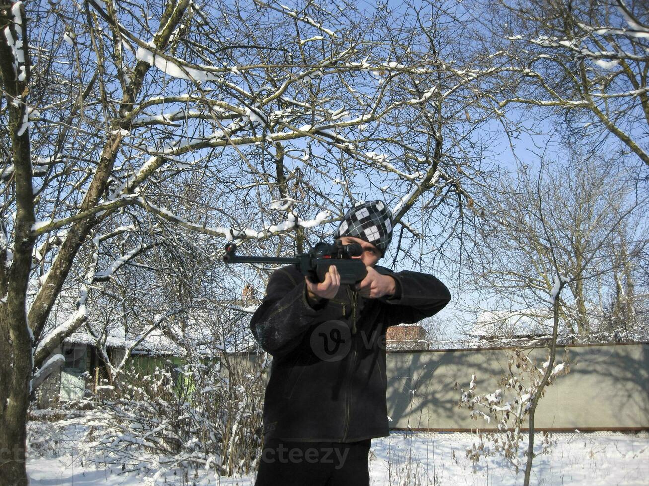 hombre con un aire rifle en un invierno parque. foto