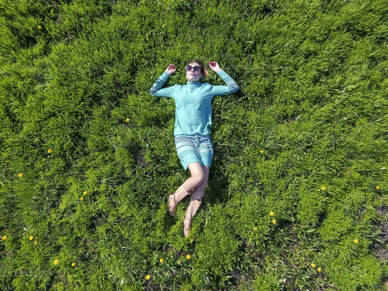 The girl lies in a turquoise dress on the lawn. beautiful girl l photo