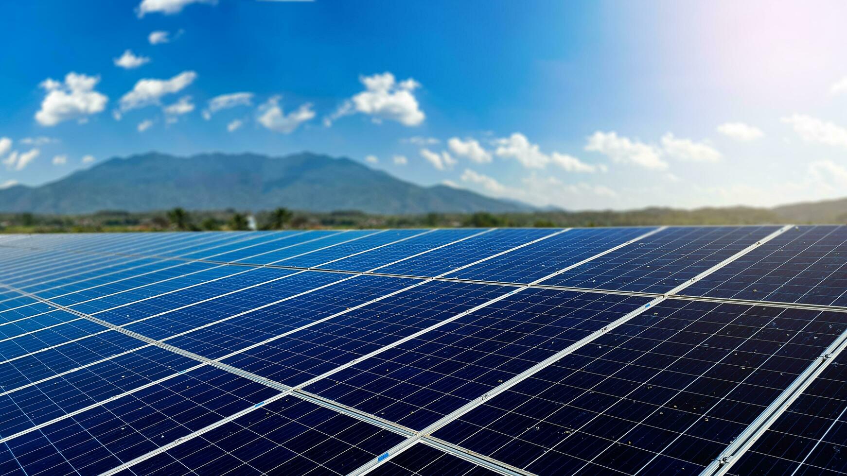 Dirty solar cell panels with blur mountains background photo