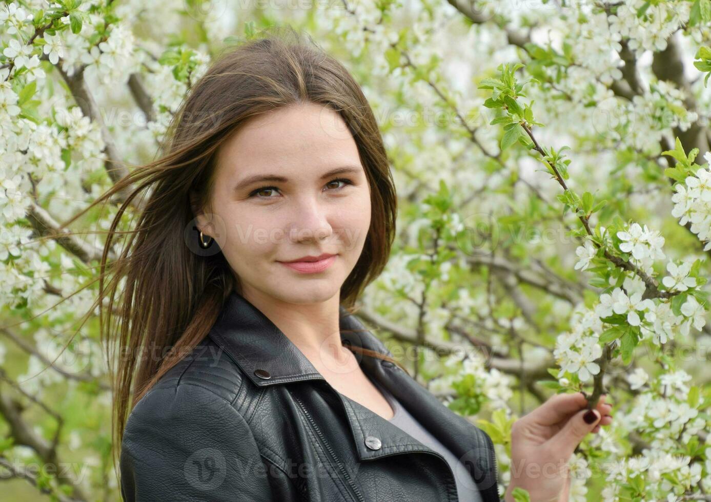 Beautiful fairy young girl in a flowering plum garden. Portrait photo