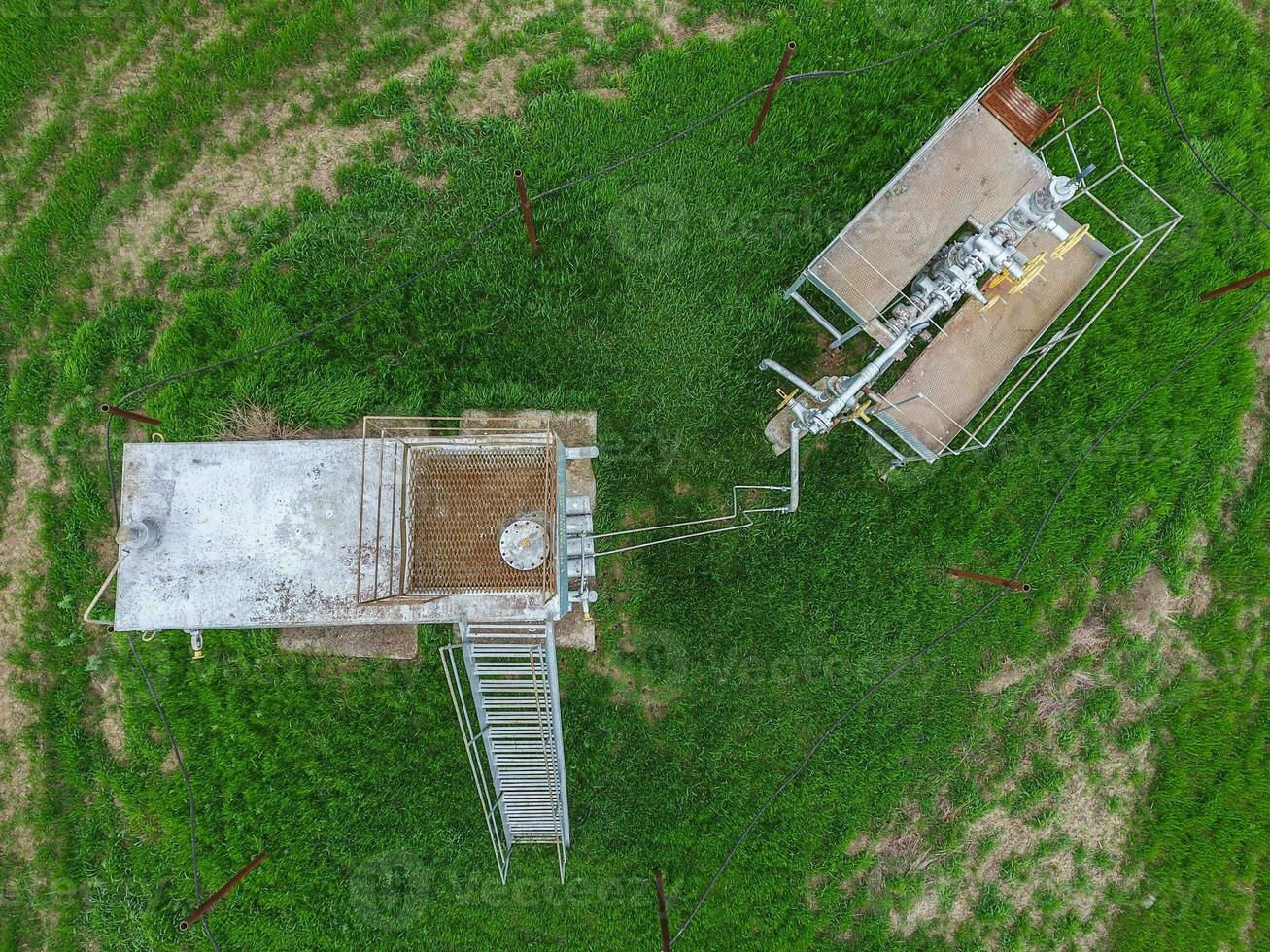 Equipment of an oil well. A tank with methanol near the oil well. Shutoff valves and service equipment photo