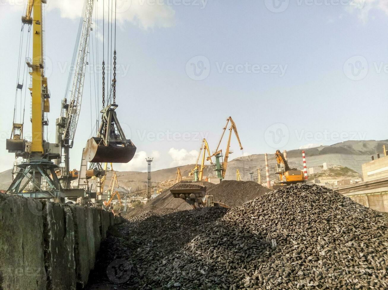 Cargo industrial port, port cranes. Loading of anthracite. Transportation of coal. Heap of coal photo