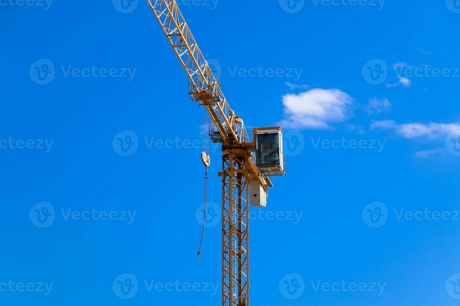 Tower building crane against the blue sky and sun. Construction of new buildings with a crane. Tower crane photo