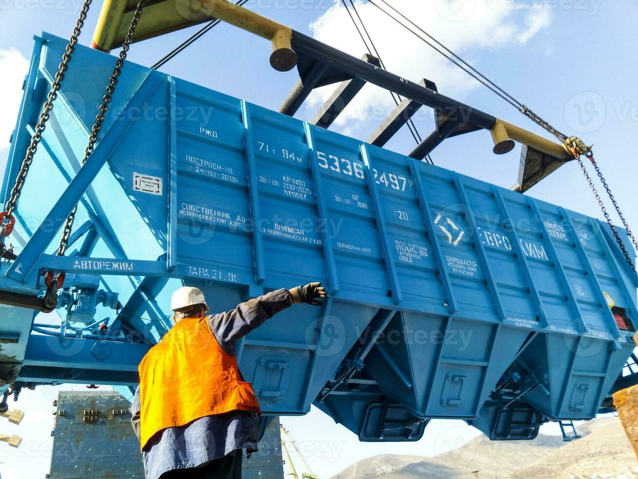 Raising the hopper car for unloading on a cargo ship. Lifting operations in the port. photo