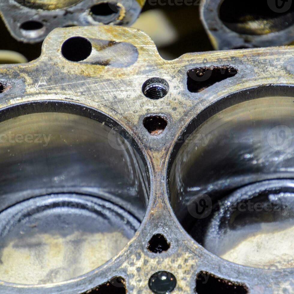 The cylinder block of the four-cylinder engine. Disassembled motor vehicle for repair. Parts in engine oil. Car engine repair in the service photo