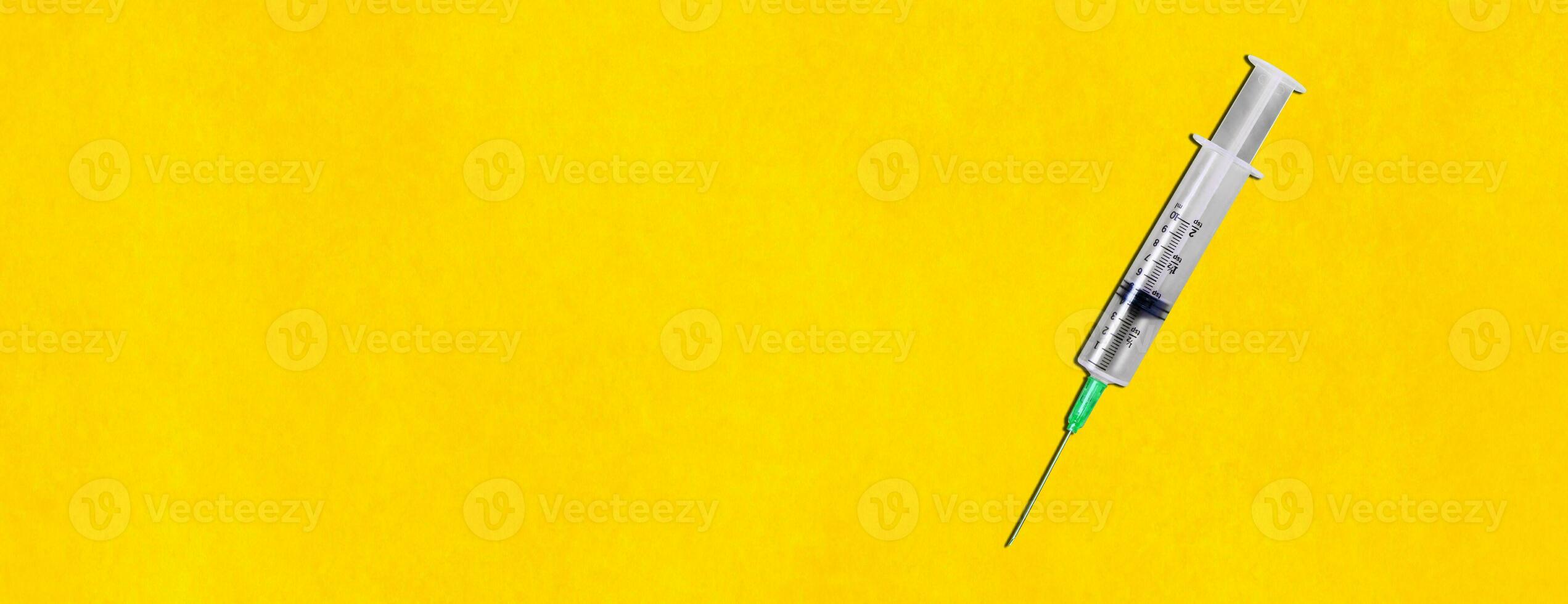 Syringe on the yellow background photo