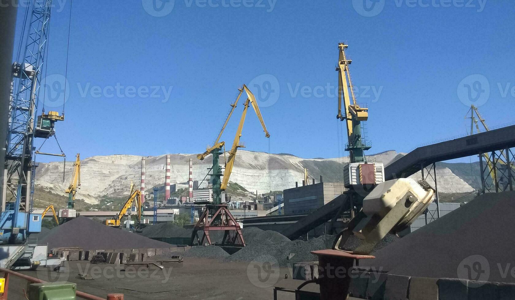 Cargo industrial port, port cranes. Loading of anthracite. Transportation of coal. Heap of coal photo