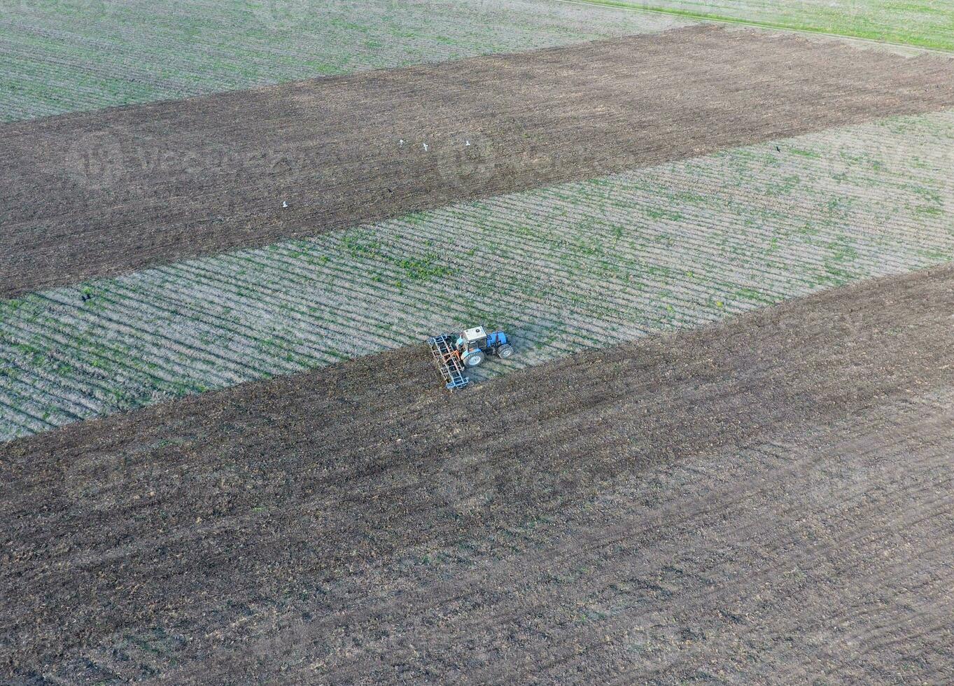 Top view of the tractor that plows the field. disking the soil. Soil cultivation after harvest photo