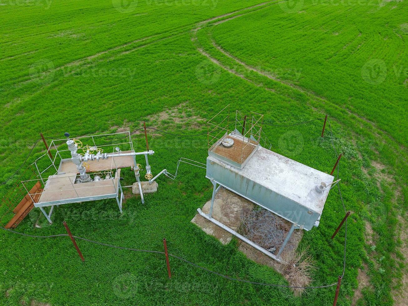 Equipment of an oil well. A tank with methanol near the oil well. Shutoff valves and service equipment photo