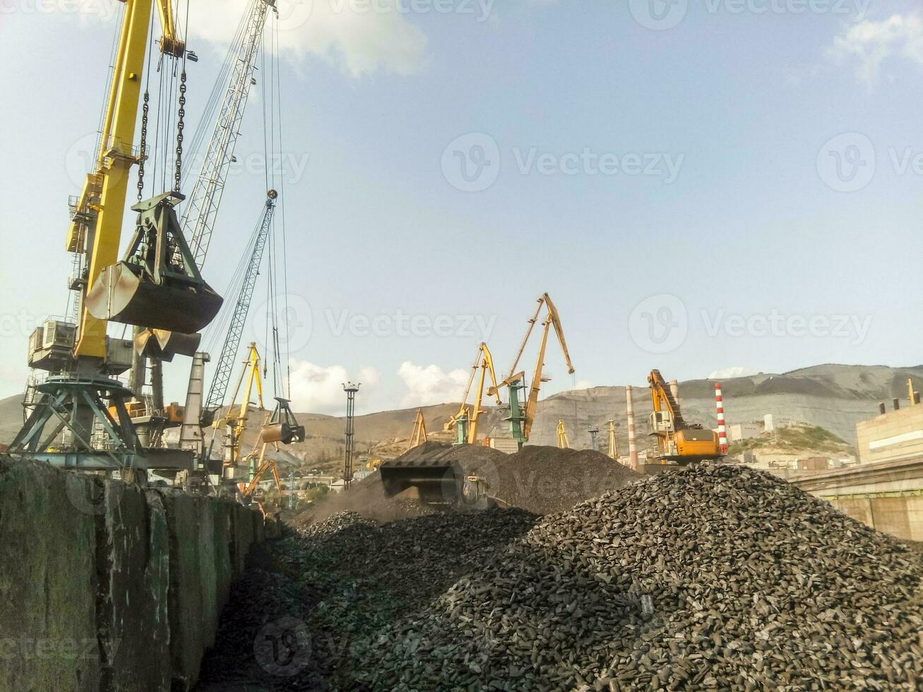 Cargo industrial port, port cranes. Loading of anthracite. Transportation of coal. Heap of coal photo