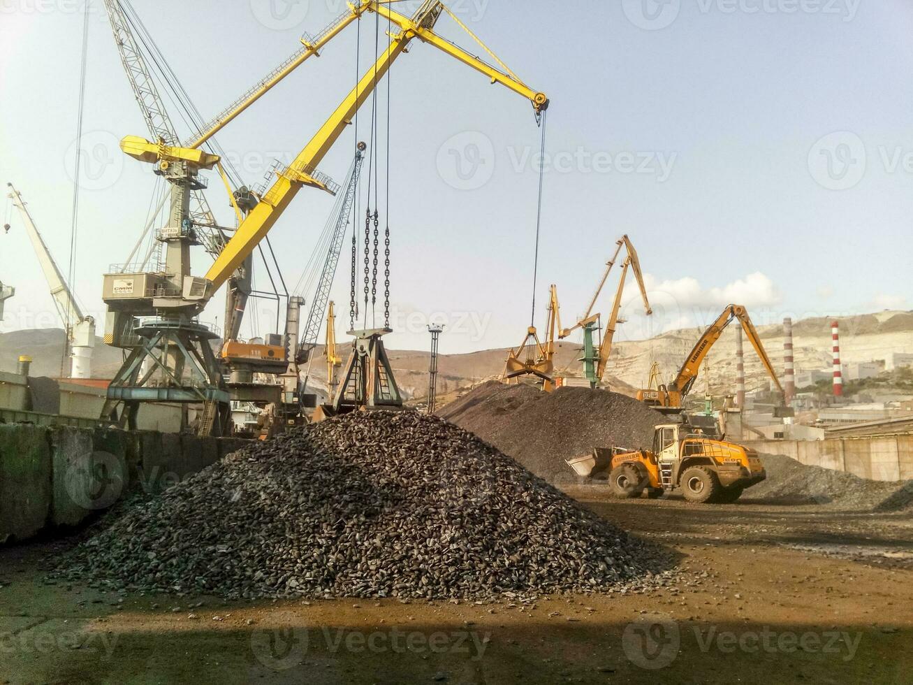 Cargo industrial port, port cranes. Loading of anthracite. Transportation of coal. Heap of coal photo