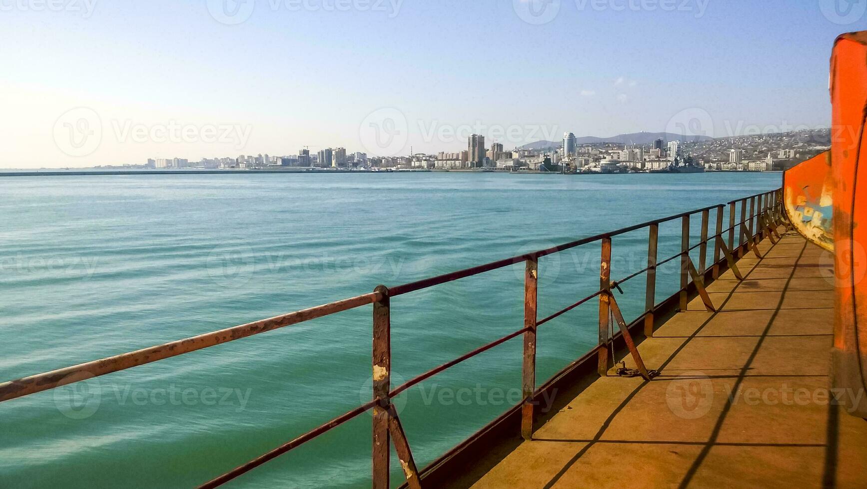 View of the sea and city beach from the port quay. Industrial port with tower cranes and cargo infrastructure photo