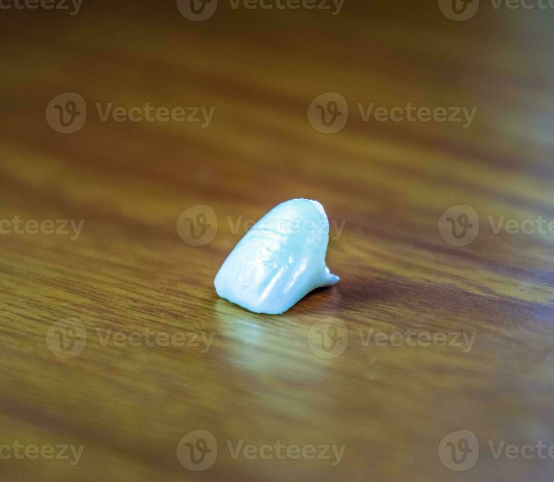 Tooth, metal ceramic crown on the table. Denture made of metal ceramics photo