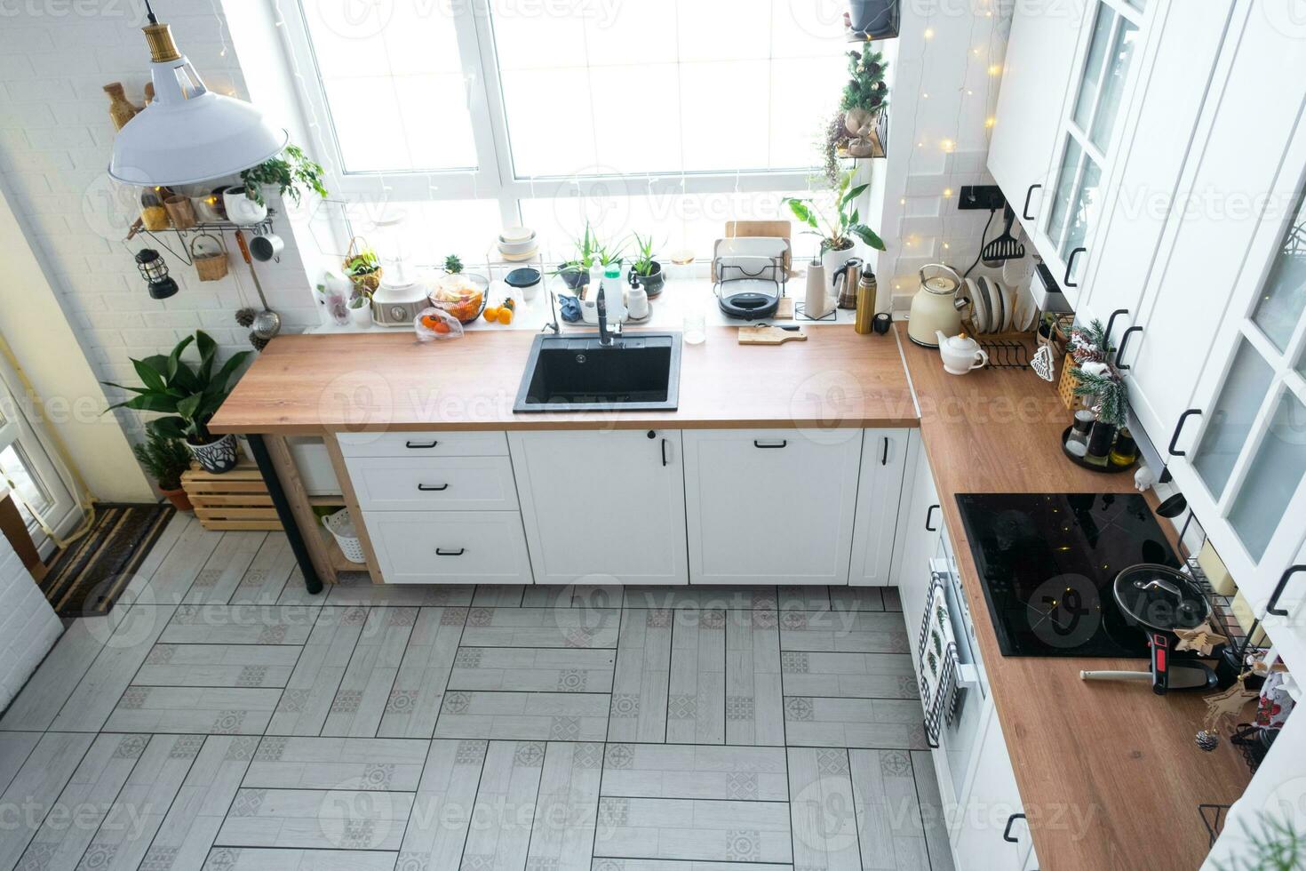 Christmas decor in white kitchen, festive mess, village interior with a snowy Christmas tree and fairy lights. New Year, Christmas mood, cozy home. photo