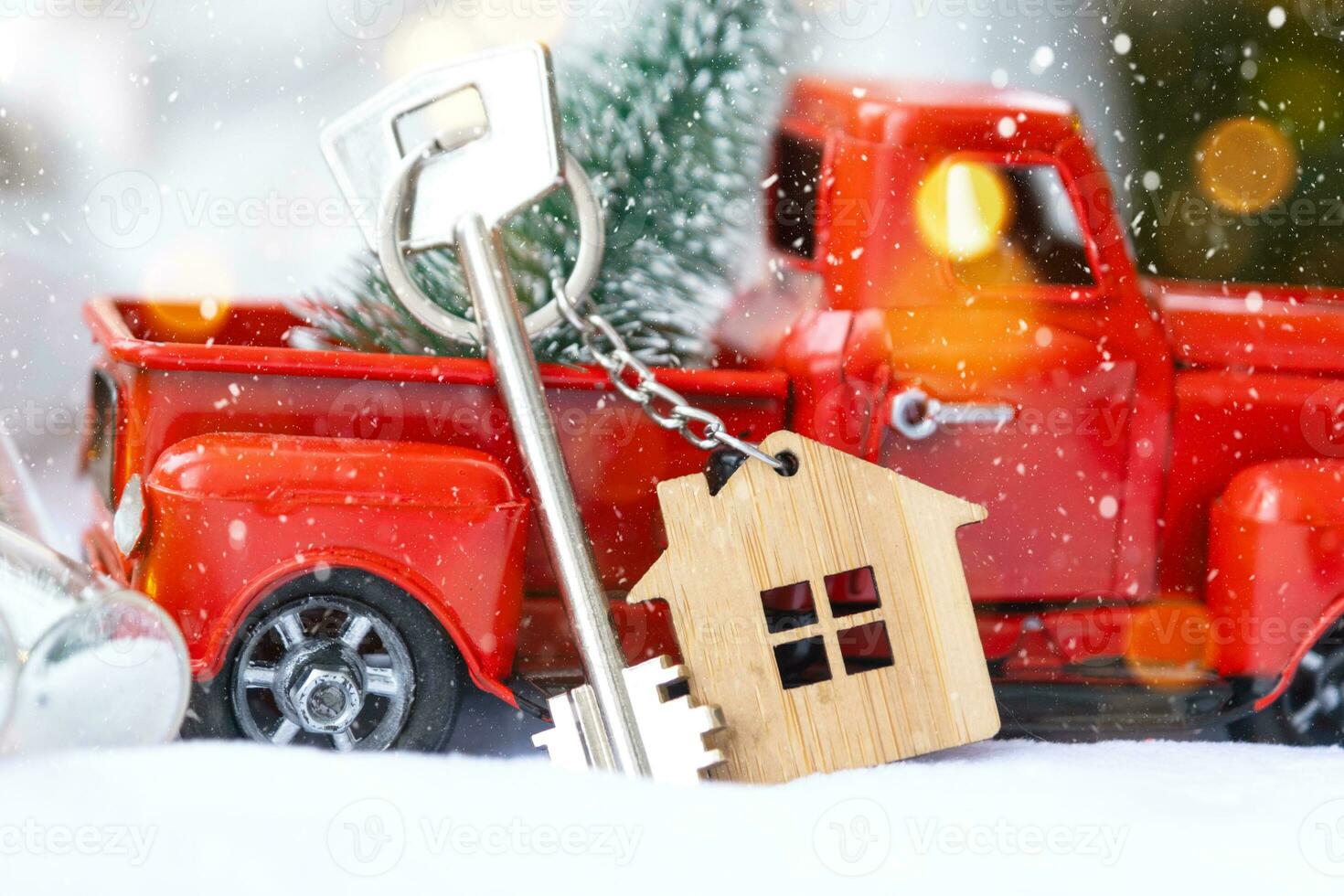 Red retro car with a Christmas tree decorates with the house key in the pickup truck for Christmas. Buying a home, moving, mortgage, loan, real estate, festive mood, New Year photo